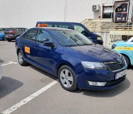 Skoda Rapid albastru cu casetă „Școala" pe plafon